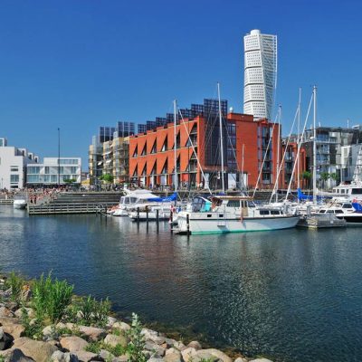Un día soleado en el puerto de Malmö con barcos amarrados y los edificios de fondo